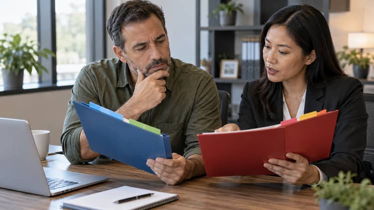 Business owner and accountant comparing financial audit and tax folders